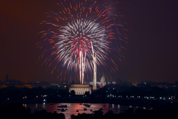Fireworks explode over the National Mall in Washington, D.C., with the Lincoln Memorial, Washington Monument, and U.S. Capitol visible at night.