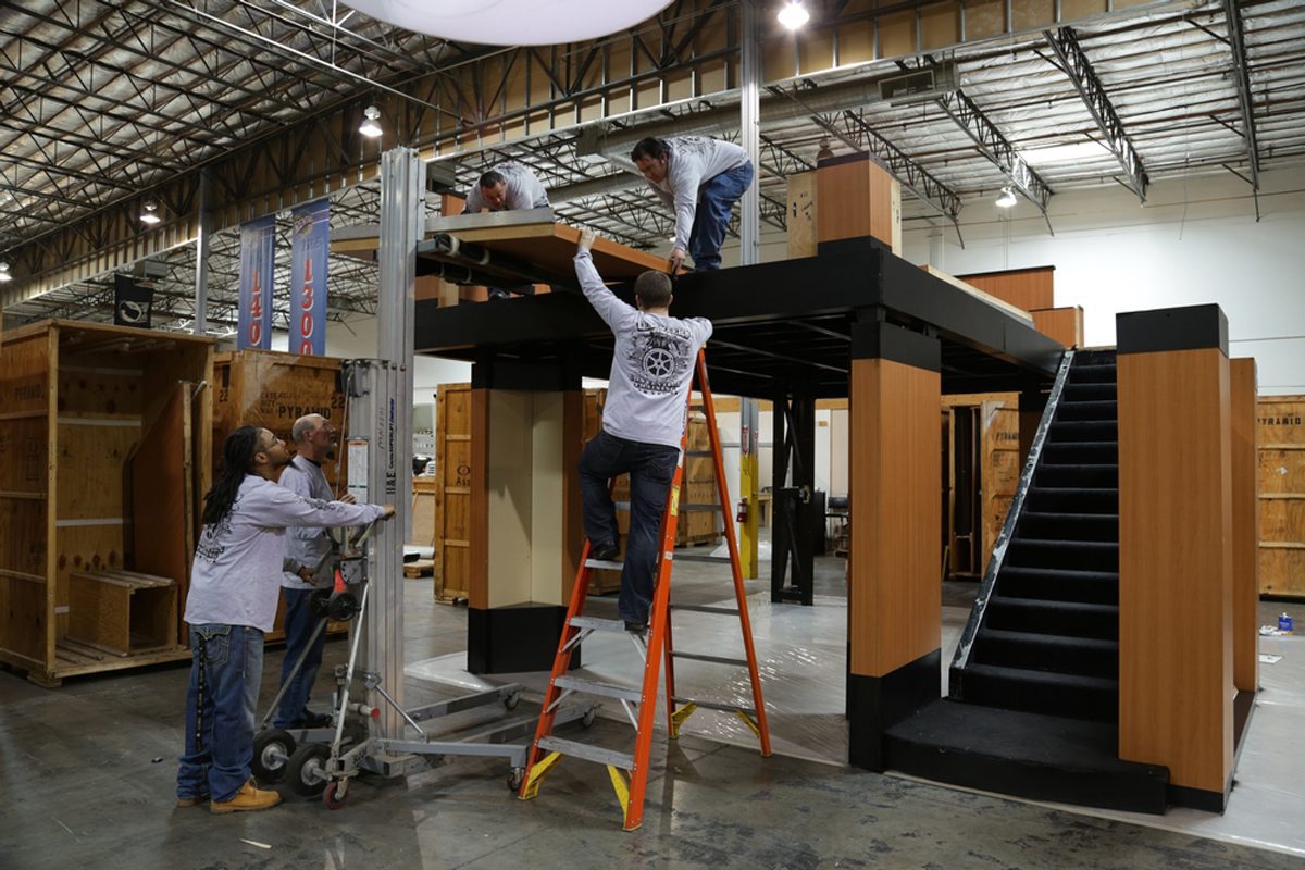 Tradeshow workers assemble a two-level exhibit during convention training.