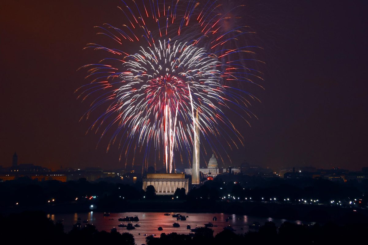 Fireworks explode over the National Mall in Washington, D.C., with the Lincoln Memorial, Washington Monument, and U.S. Capitol visible at night.
