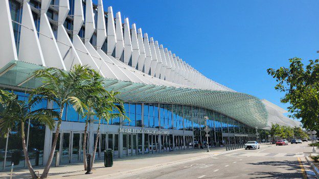 Exterior of Miami Beach Convention Center with palm trees and glass entrance.