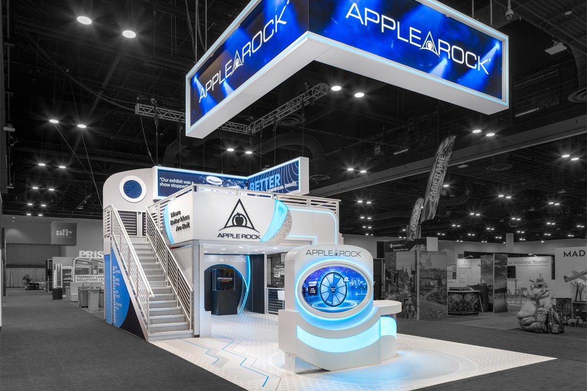 Apple Rock double-deck booth with LED hanging sign at ExhibitorLIVE 2026.