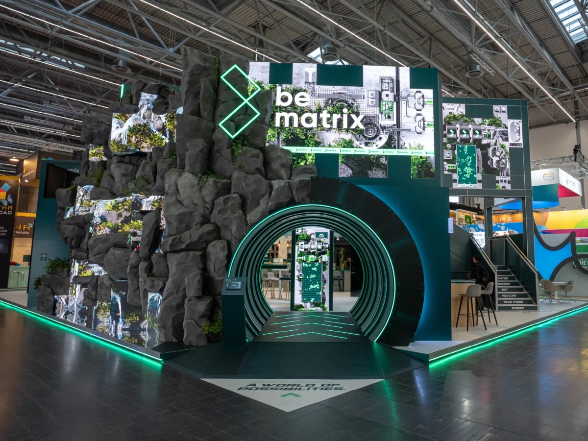 beMatrix modular exhibit with rock-inspired structures, digital displays, and an illuminated circular entrance