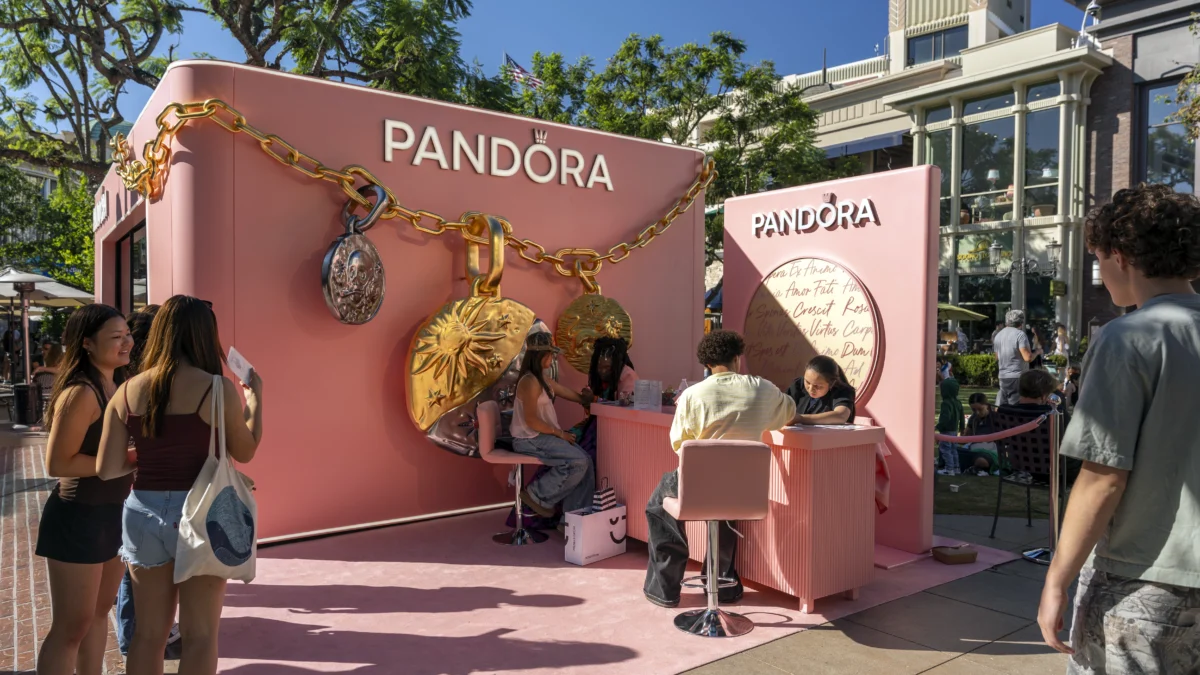 Pandora event activation with oversized jewelry graphics, pink branding, and guest stations