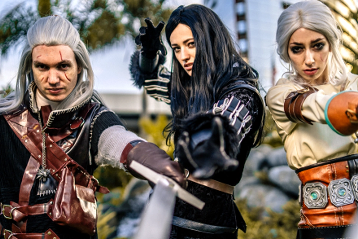 Three cosplayers pose with prop weapons outside Comic-Con in San Diego