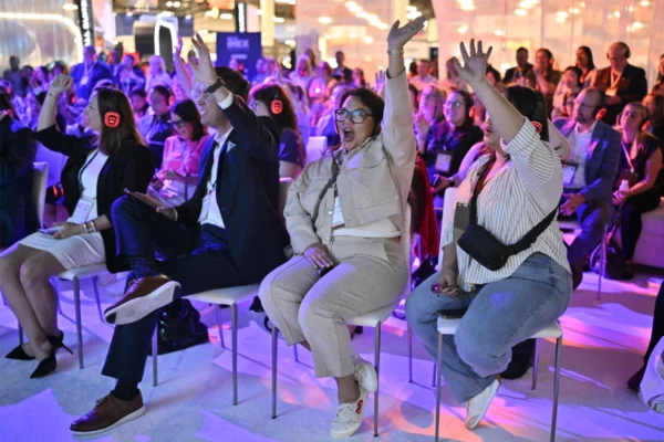 IMEX America education session attendees raise their hands while wearing wireless headphones