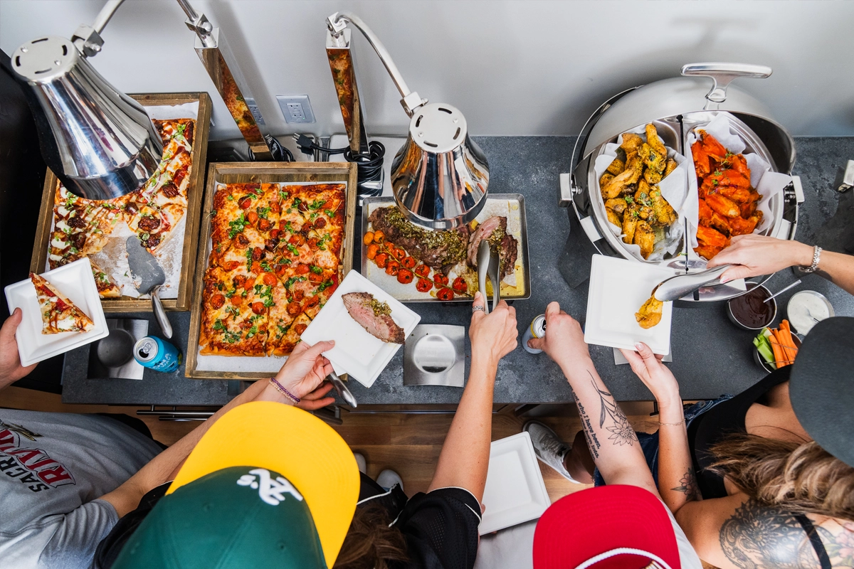 Guests select food from a buffet at a live event