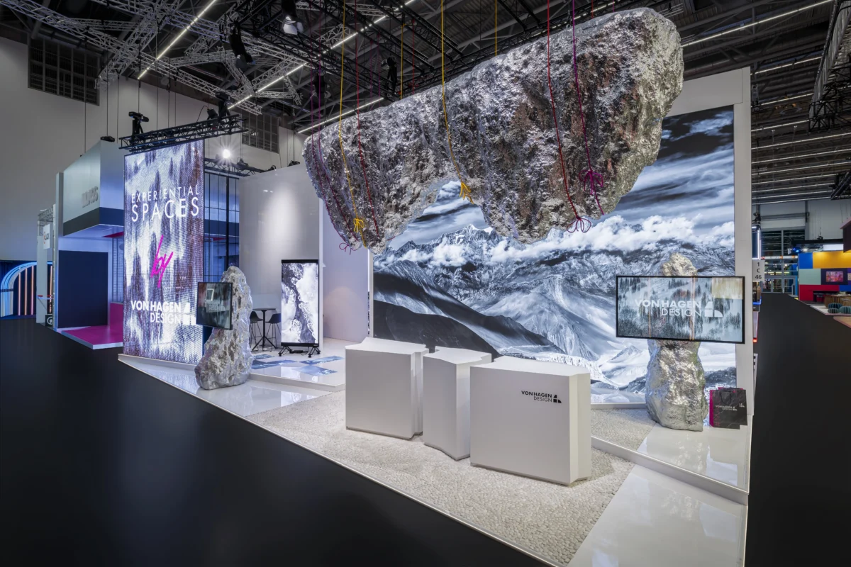 Von Hagen Design international exhibit with suspended rock forms, mountain graphics, and digital displays