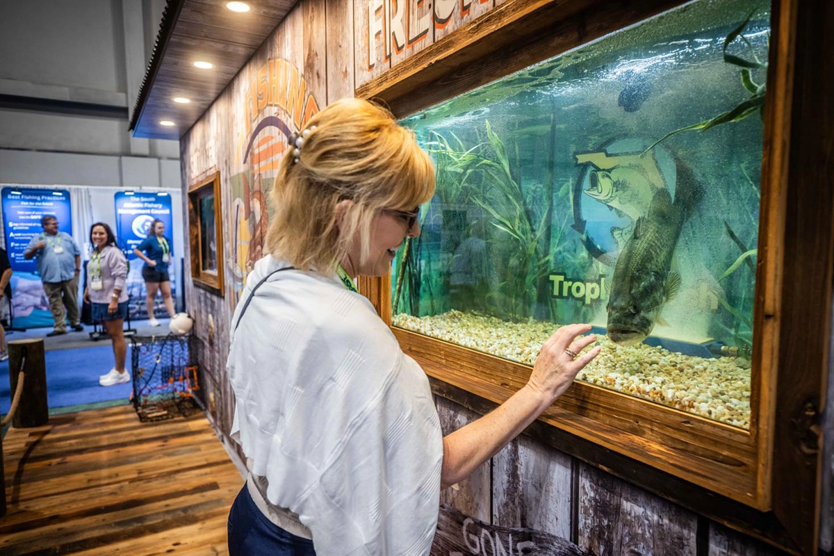 Attendee views a live fish display on the ICAST show floor in Orlando