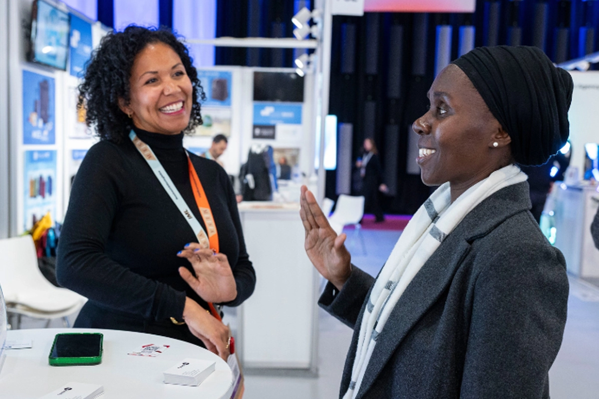 Julia Danmeri of TranslateAble speaks with an attendee at IBTM