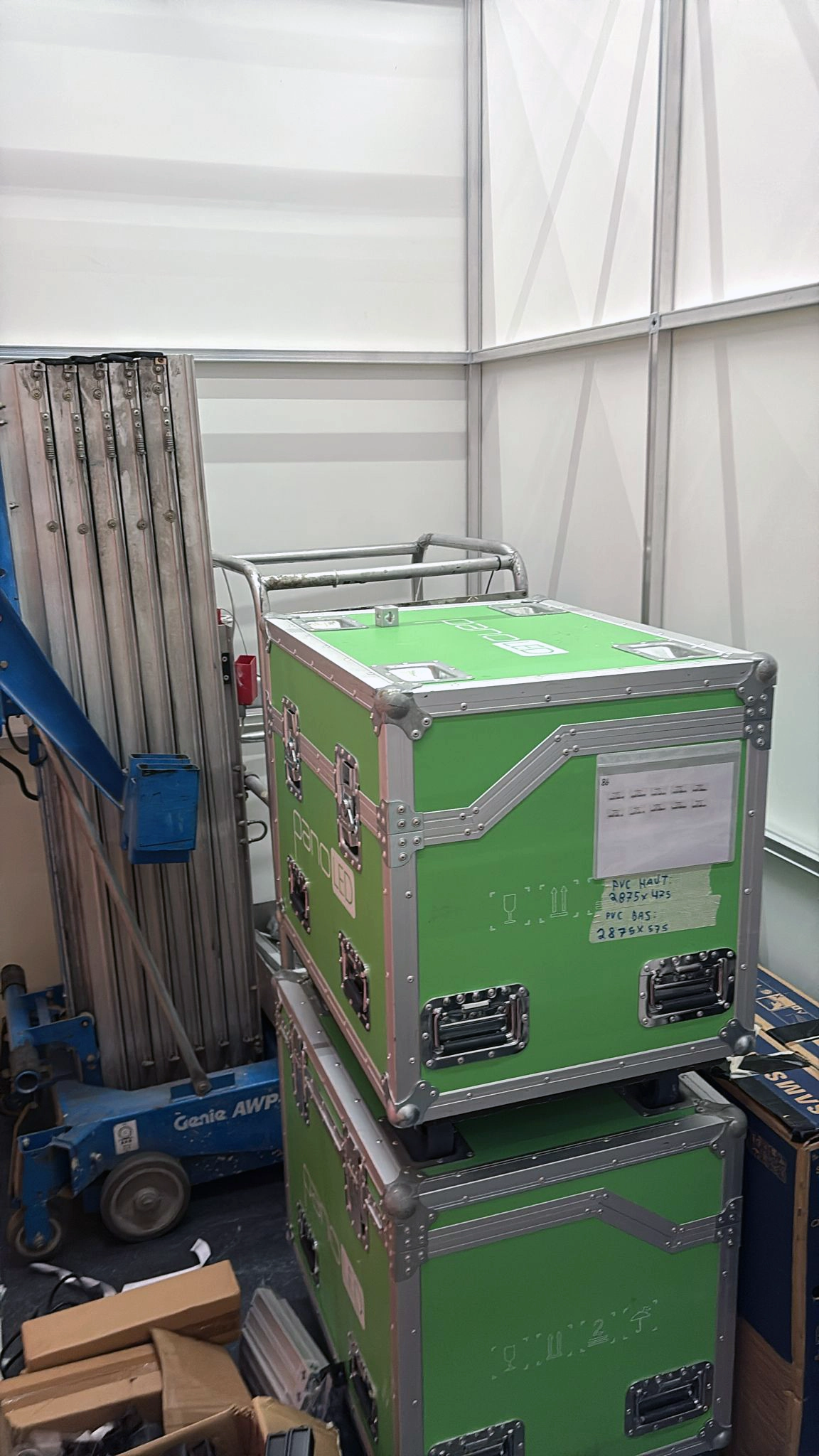 Green flight cases stored inside a T3 Systems stand during installation