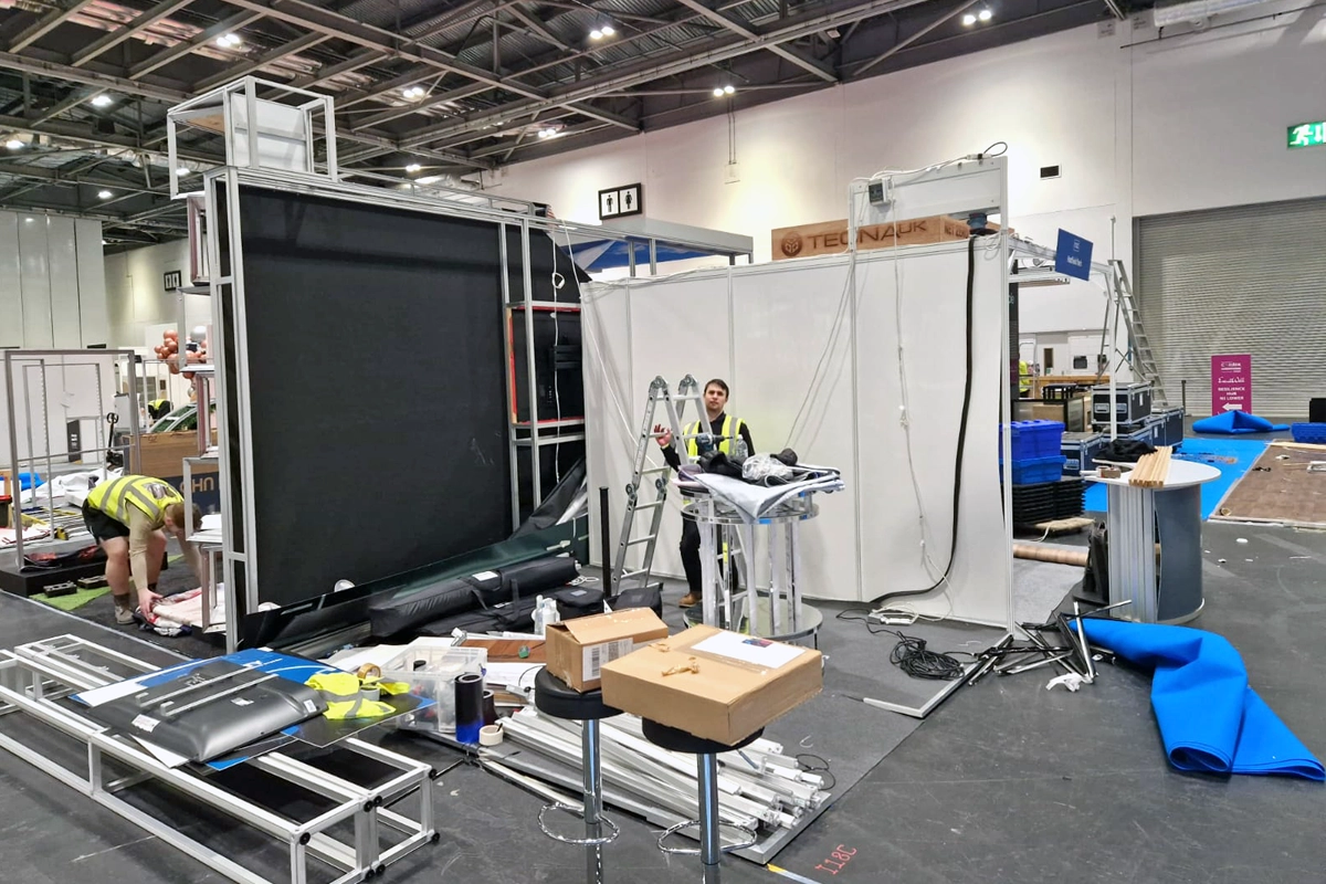 T3 Systems crew members install a tradeshow stand using their own tools and ladders