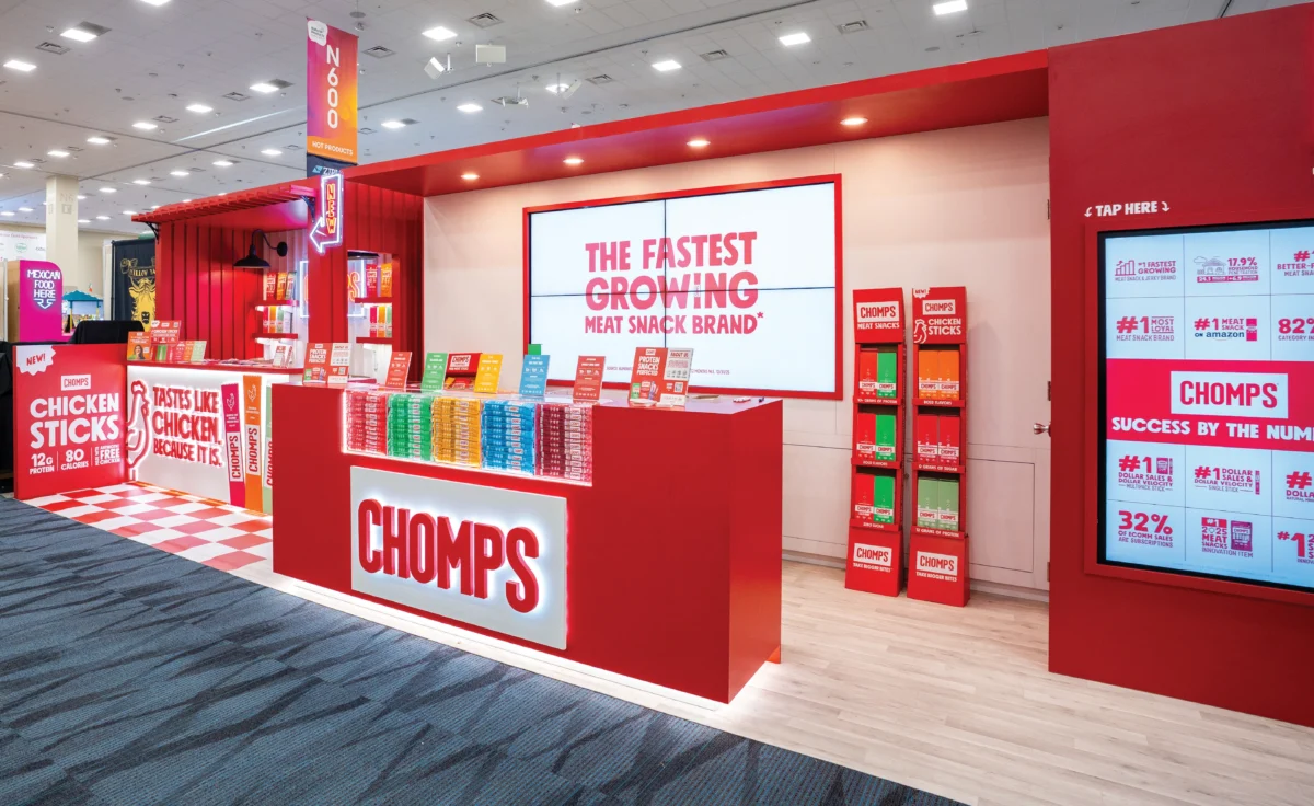 Red Chomps exhibit with product displays, a sampling counter, and large screens