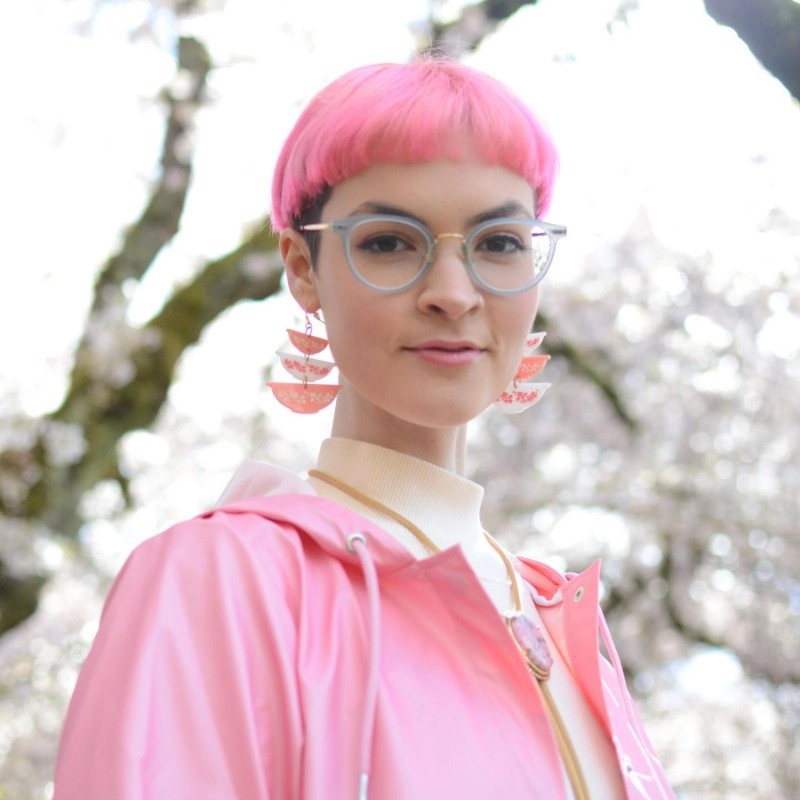 Grace Warnick wearing glasses and a pink jacket outdoors