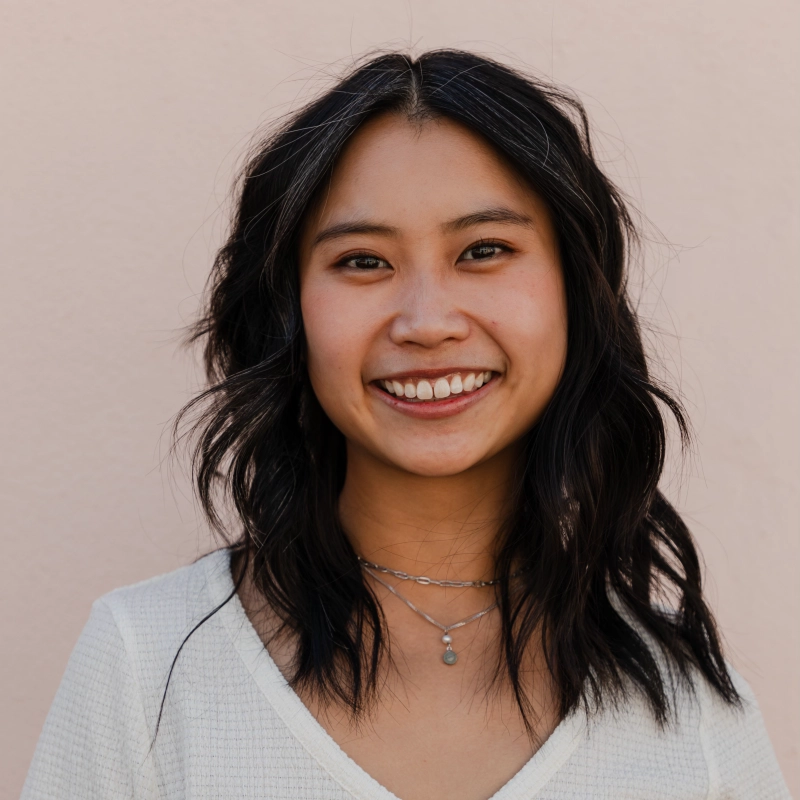 Lydia Lee smiling in a light top against a plain background