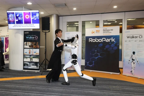UBTECH’s Walker C1 humanoid robot dances with a partner beside RoboPark signage at an HKTDC press conference.