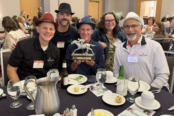 Five Captivate Exhibits team members pose with an award at a banquet