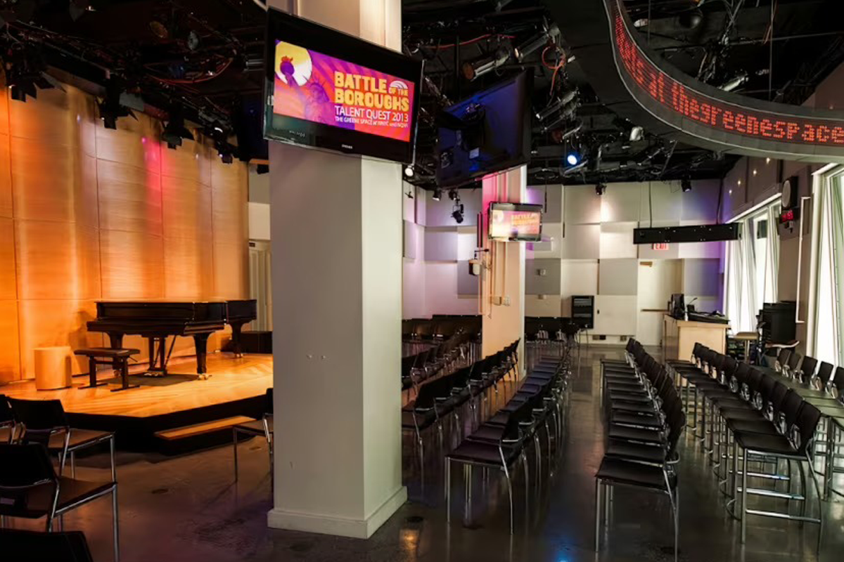 Rows of chairs face a stage with a grand piano inside The Greene Space at WNYC in New York.