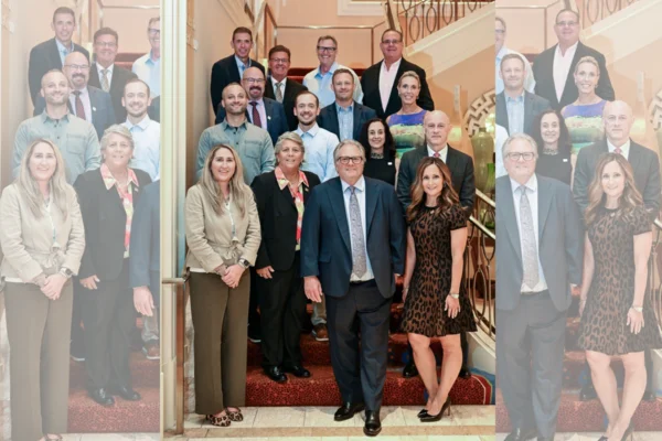 PRINTING United Alliance board members pose together on an indoor staircase.