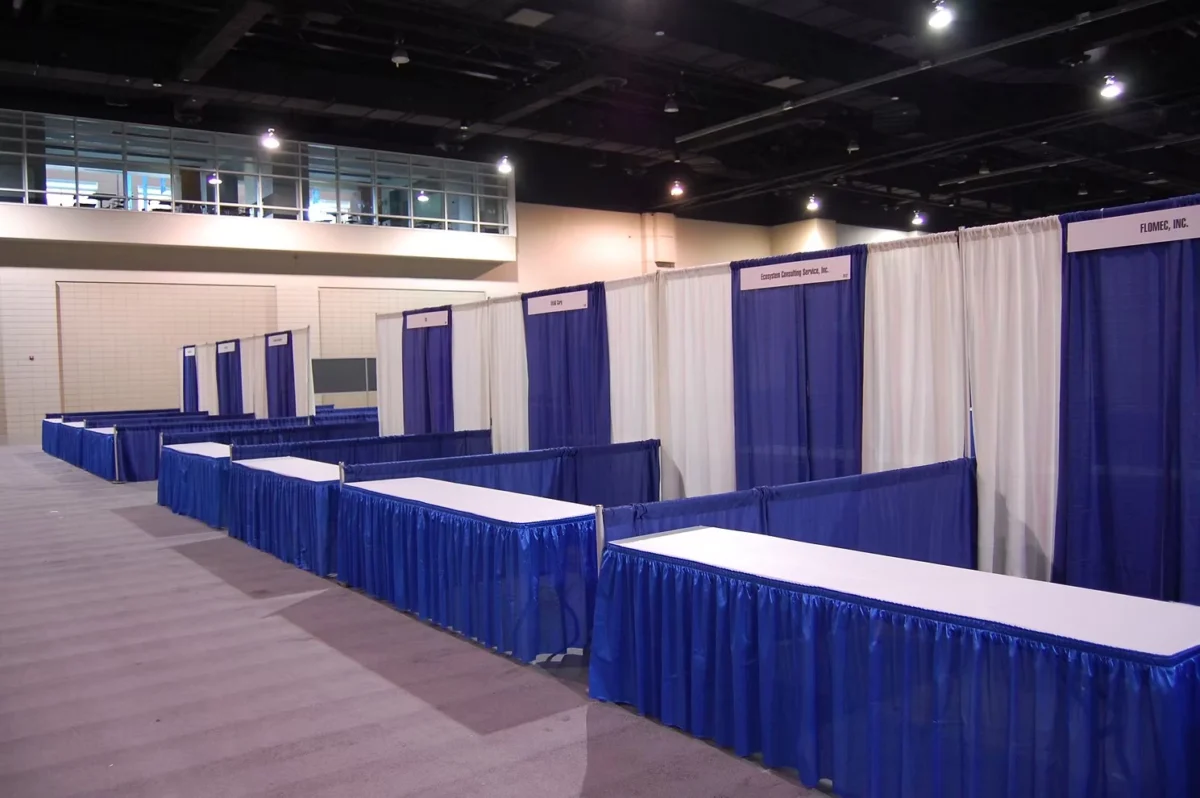 U.S. pipe-and-drape tradeshow booths with fabric walls and tables