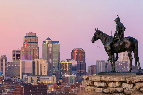 The Scout statue overlooks the Kansas City skyline at dusk