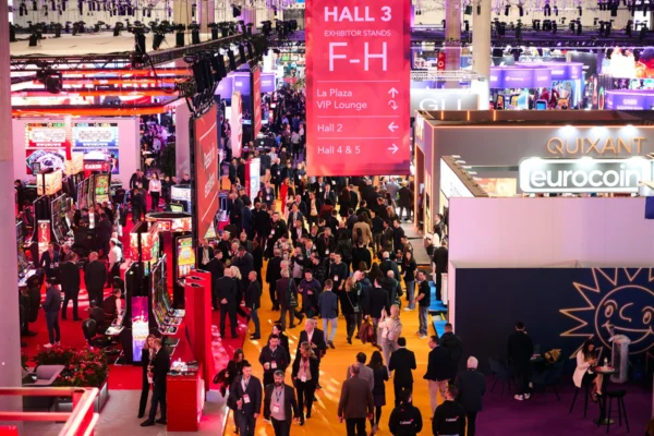 Attendees fill a busy ICE exhibition aisle surrounded by gaming displays and exhibitor booths beneath Hall 3 signage.