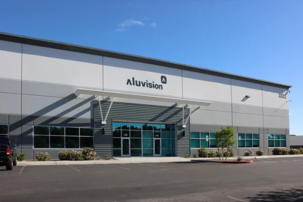 Exterior of Aluvision’s Las Vegas facility with company signage above glass entrances and a covered entryway.