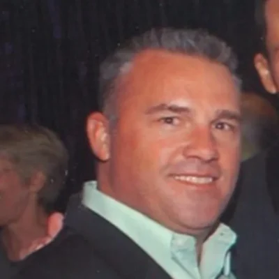 Matt Naert, senior director of strategic account programs at Circle Studios, smiles while wearing a dark jacket and light green collared shirt.